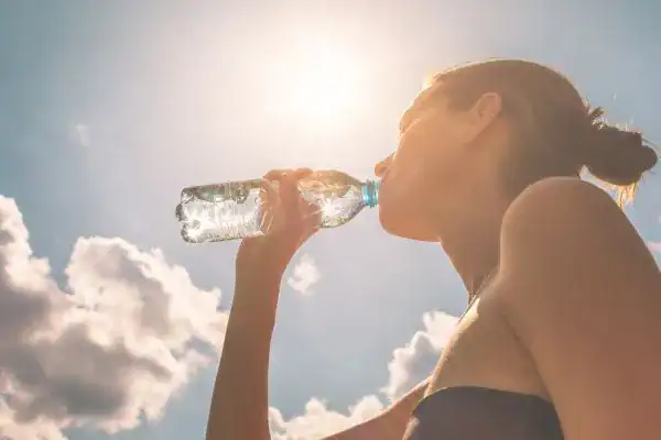 Hydration: The Secret Ingredient for a Toned Stomach and Enhanced Fitness 3 Image of woman drinking water to hydrate Blackheath after run.