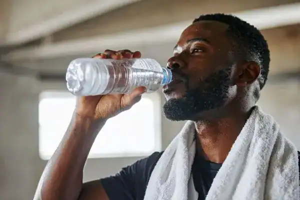 Image of man drinking water to improve hydration Blackheath after work out.
